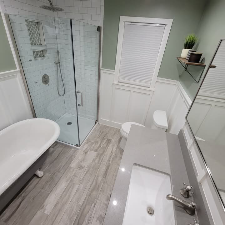 bathroom remodel with glass shower surround and custom wainscoting