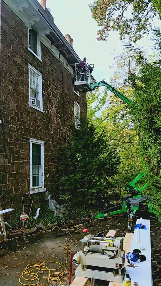 contractor in lift remodeling the soffit and fascia of a historic home